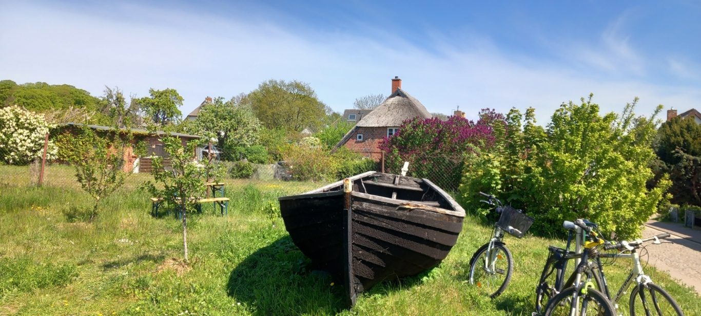 Groß Zicker - Fischerboot im Ortsbild Altes Fischerboot und Fahrräder an der Ortsstraße in Groß Zicker